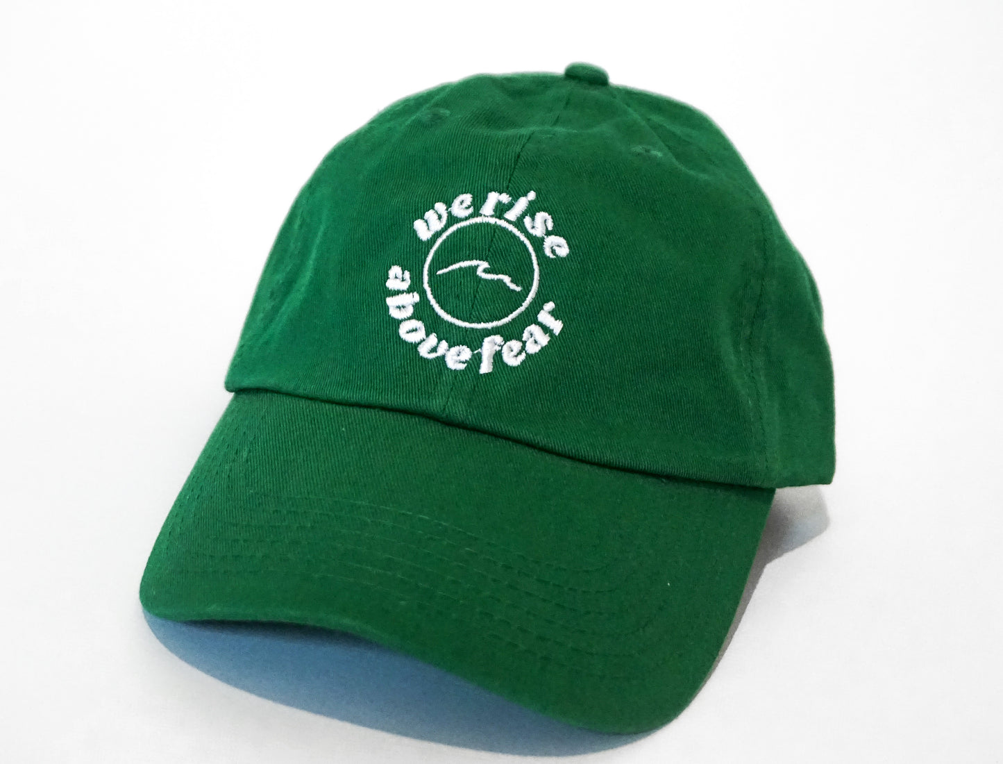 unstructured dad hat in the color kelly green. waves. We rise above fear logo. the fearless co. 100% cotton.