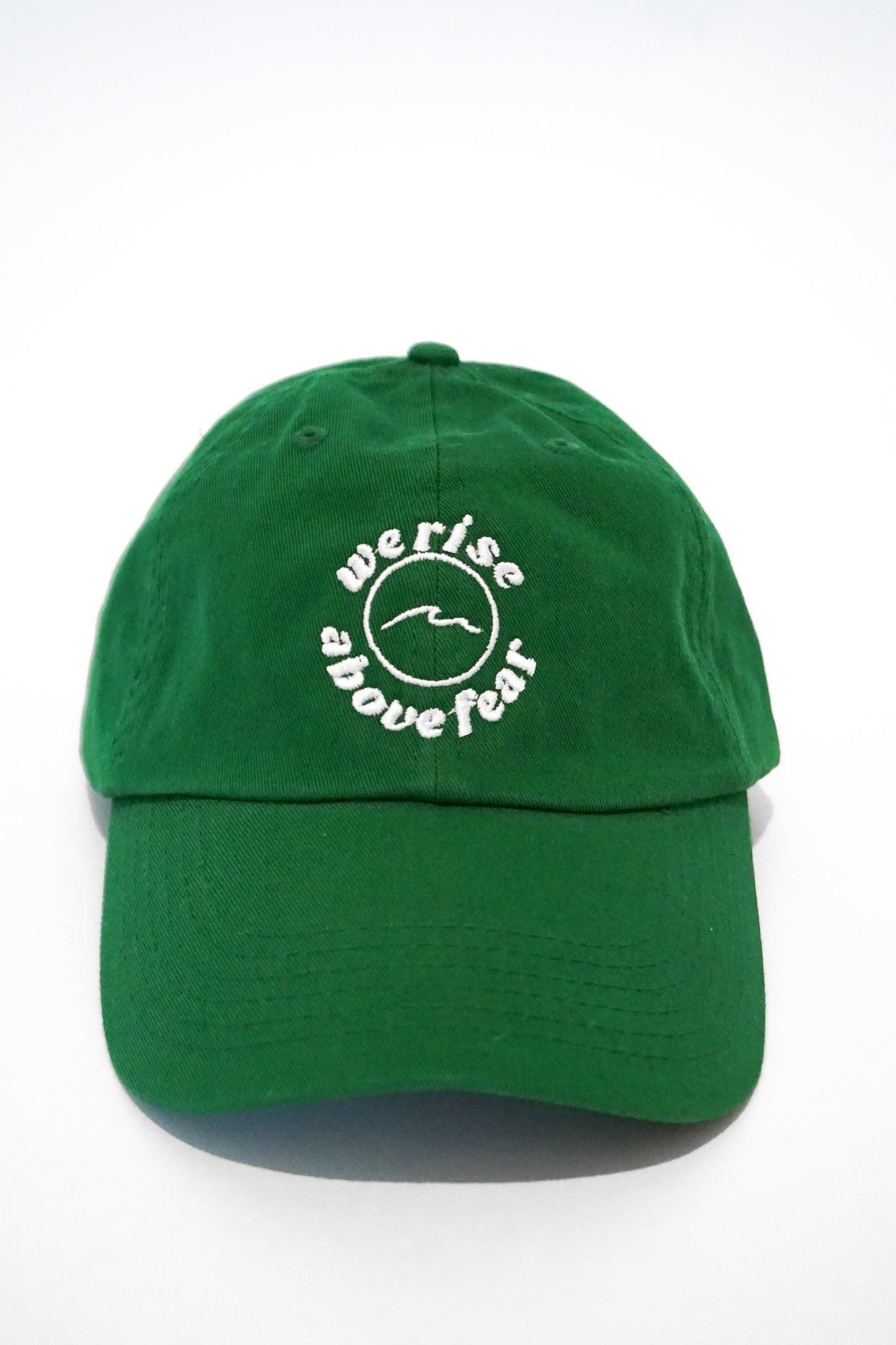 unstructured dad hat in the color kelly green. waves. We rise above fear logo. the fearless co. 100% cotton.